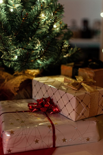 绿色圣诞树旁的棕色和白色礼品盒